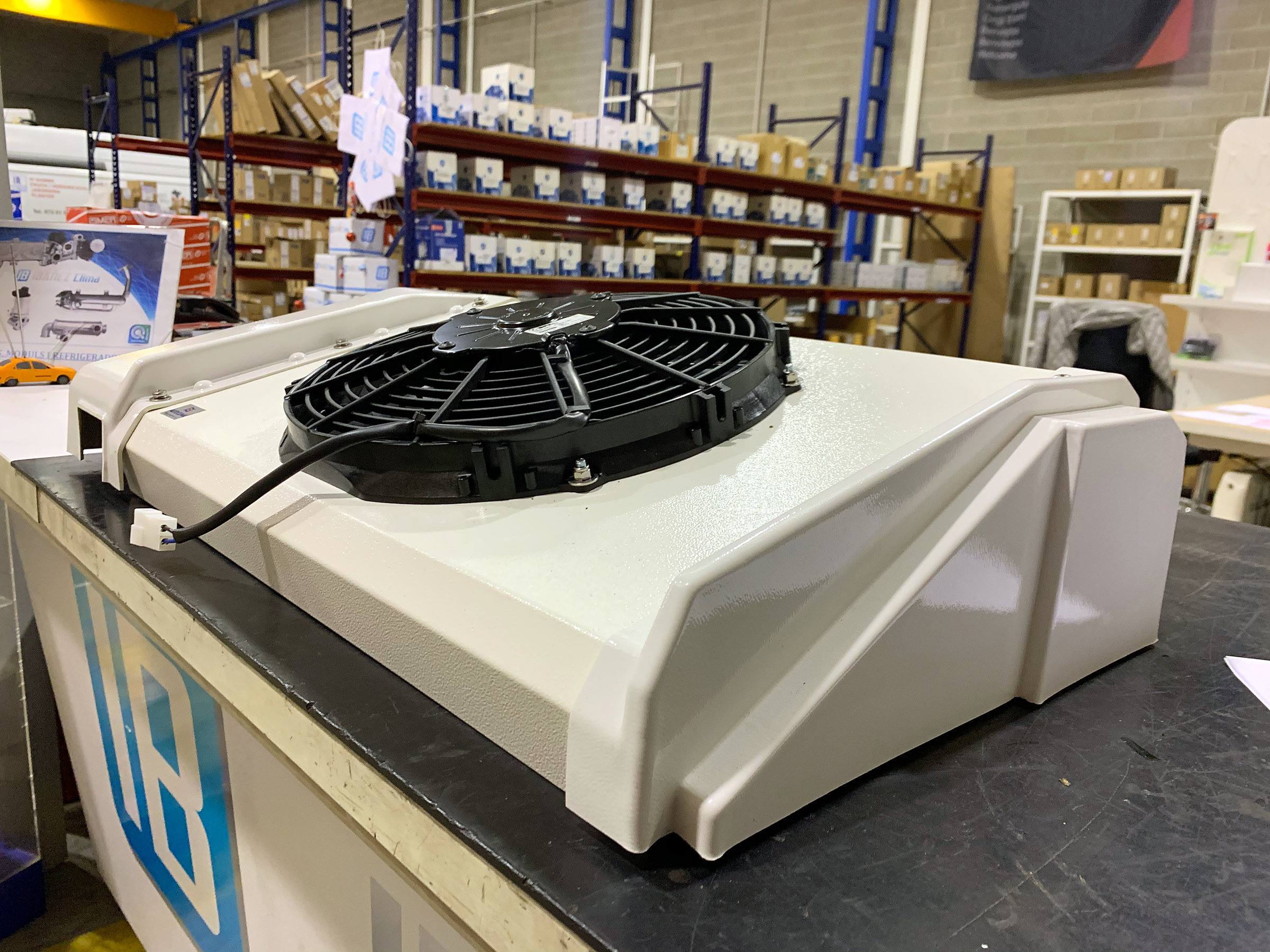 Condensador con electroventilador sobre el mostrador de IBAÑEZ CLIMA, con el almacén de recambios al fondo.