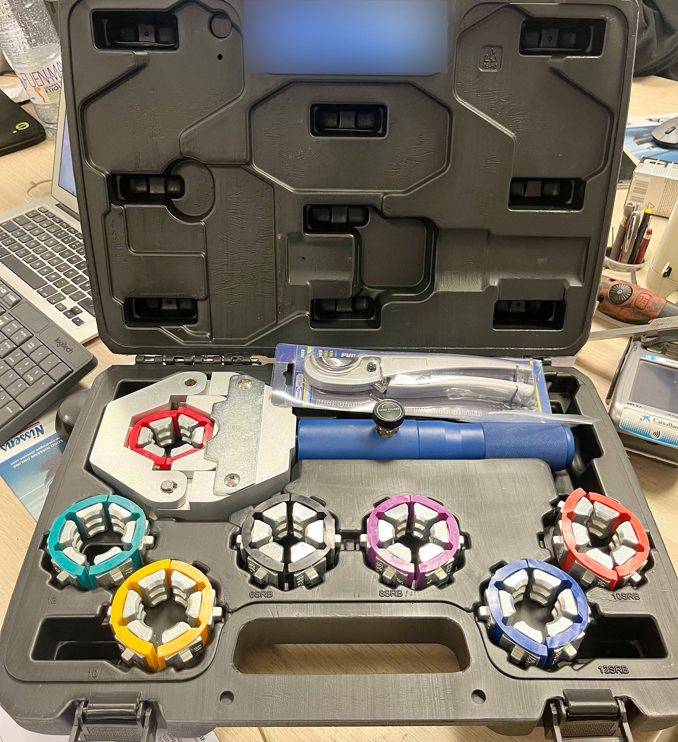 Maletín de crimpado con matrices para fabricar mangueras de aire acondicionado a medida.